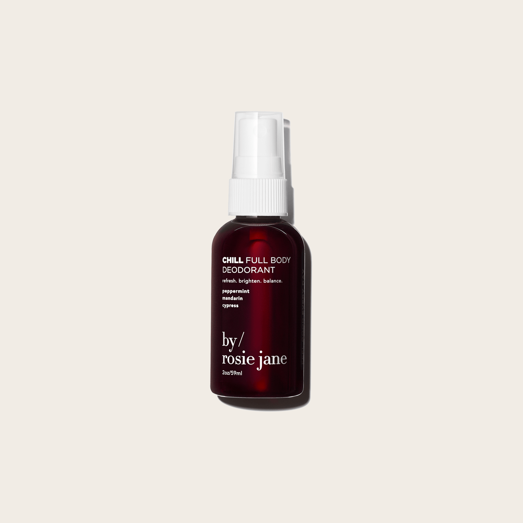 A dark amber spray bottle labeled CHILL FULL BODY DEODORANT by byrosiejane—aluminum-free and ideal for sensitive skin—stands against a beige background, featuring minimalist design and a white spray cap.