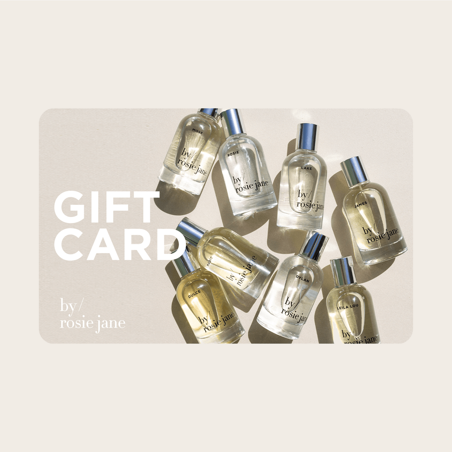 Several bottles of by/rosie jane perfumes are arranged on a light surface with sunlight casting shadows. The words FRAGRANCE DISCOVERY SET + $80 E-GIFT CARD and by/rosie jane appear on the left in white text, perfect for gifting.