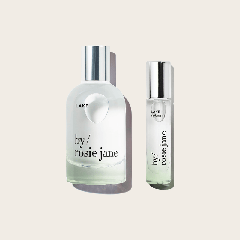 The byrosiejane LAKE LAST ALL DAY SET features two clear glass bottles—a large Eau de Parfum spray and a smaller Perfume Oil roller—both with silver caps and minimalist labels for a long-lasting fragrance experience.