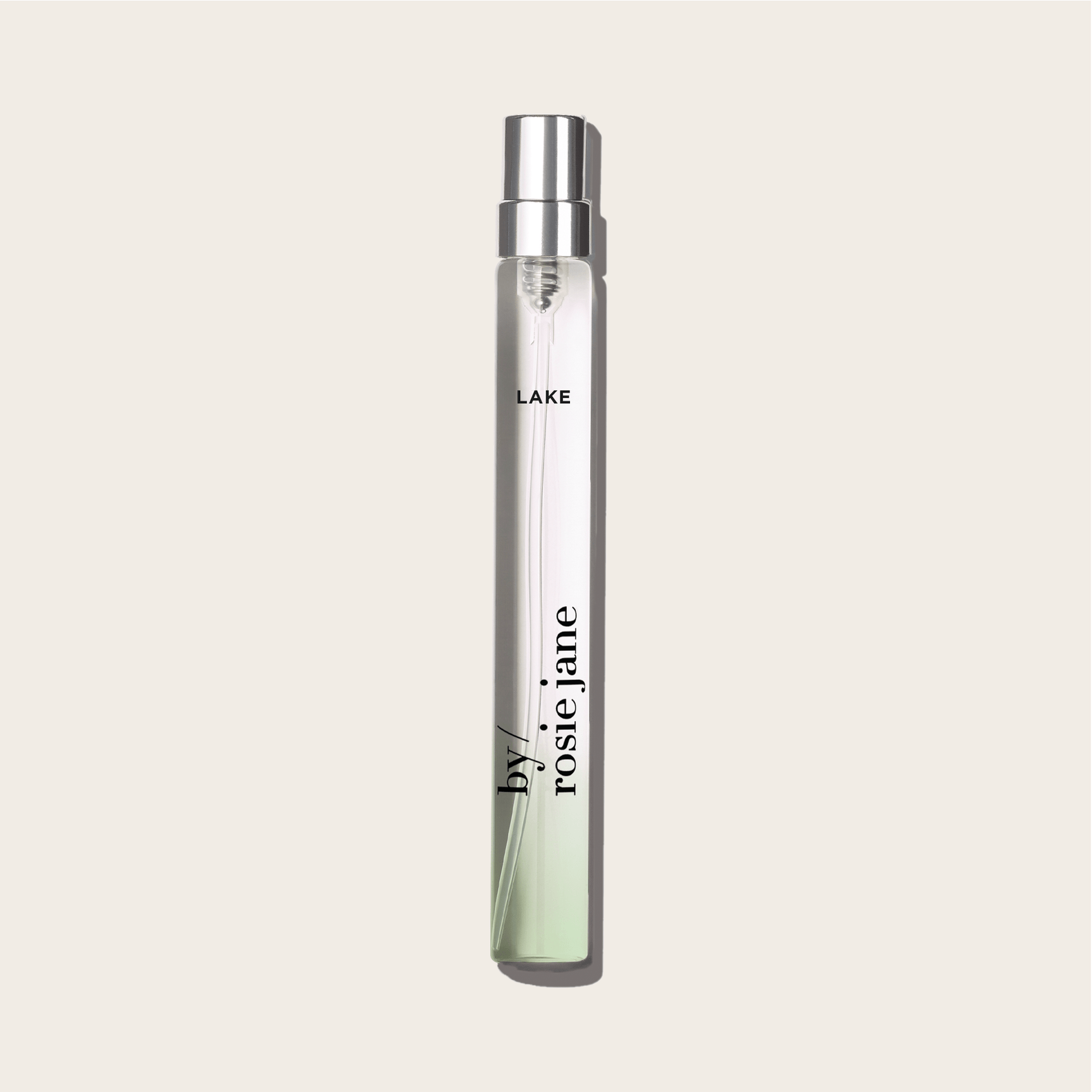 The LAKE TRAVEL SPRAY by byrosiejane is a clear glass perfume vial with a silver cap, featuring neroli and vanilla sandalwood notes inspired by Lake Tahoe.