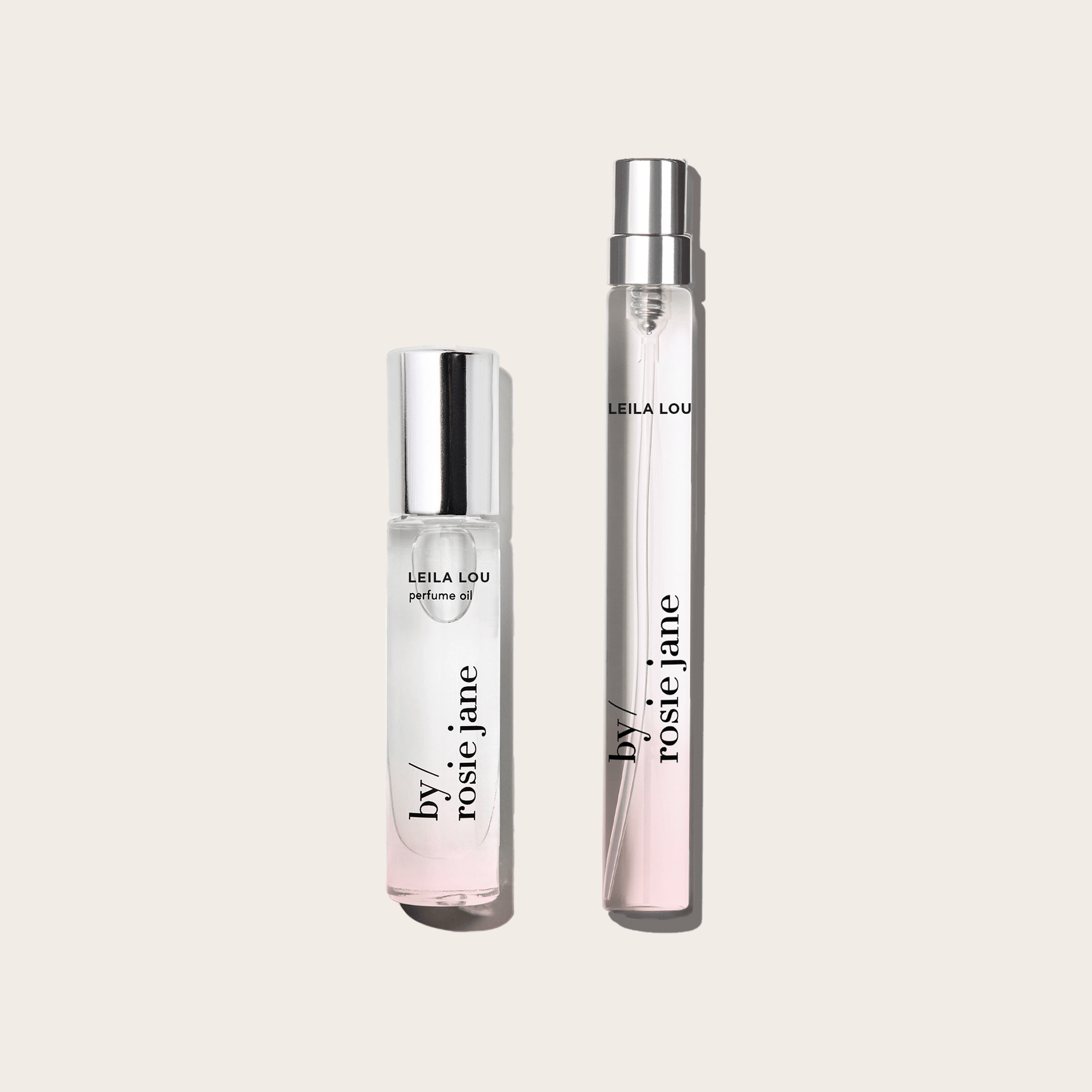 The LEILA LOU 2 WAYS TRAVEL SET by byrosiejane features two clear glass bottles—a handy travel spray and a taller Eau de Parfum with silver caps—both filled with light pink fragrance, ideal for scent lovers on the go.