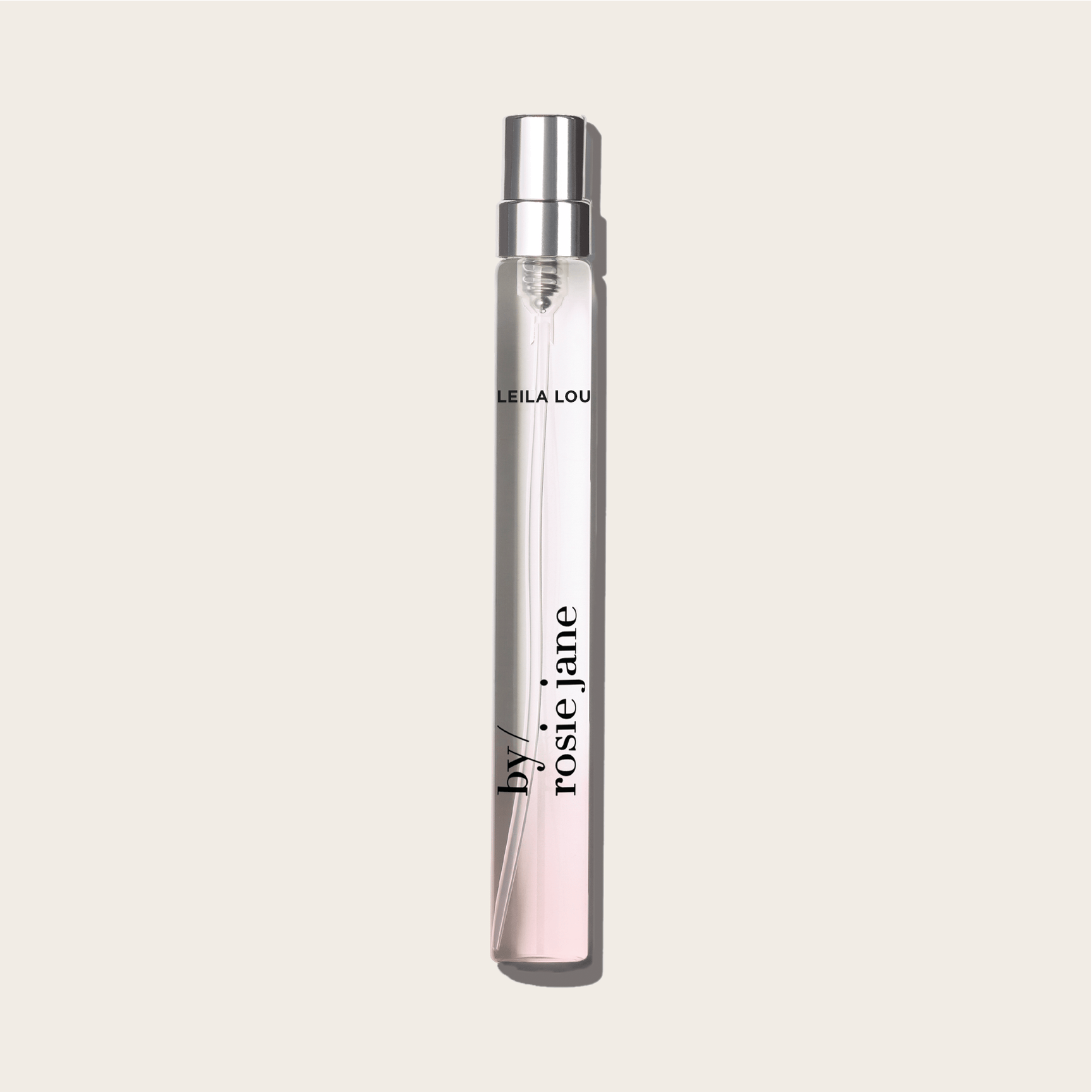 The LEILA LOU TRAVEL SPRAY by byrosiejane stands upright on a light beige background, its clear glass bottle with a silver cap labeled in black, evoking fresh cut grass and delicate jasmine.