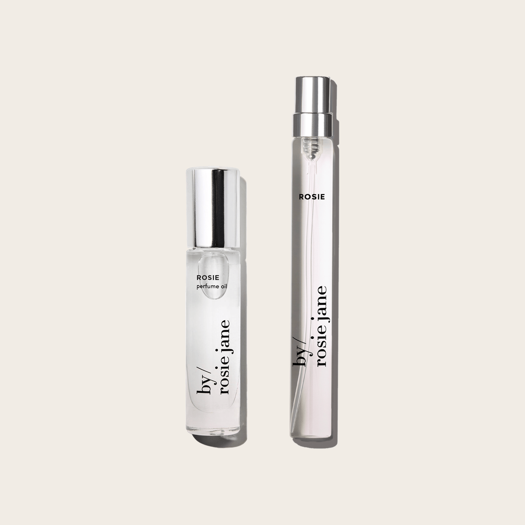 The byrosiejane 2 WAYS TRAVEL SET features two clear perfume bottles with silver caps—one perfume oil and one travel spray labeled ROSIE—displayed side by side on a light beige background.