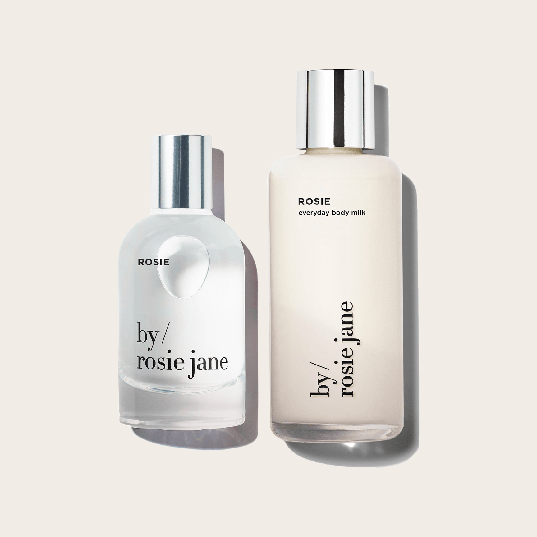 The ROSIE YOU SMELL GOOD DUO by byrosiejane features two clear bottles with silver caps on a beige background—ROSIE eau de parfum and everyday body milk—both offering an effortlessly soft, modern nude musk scent.