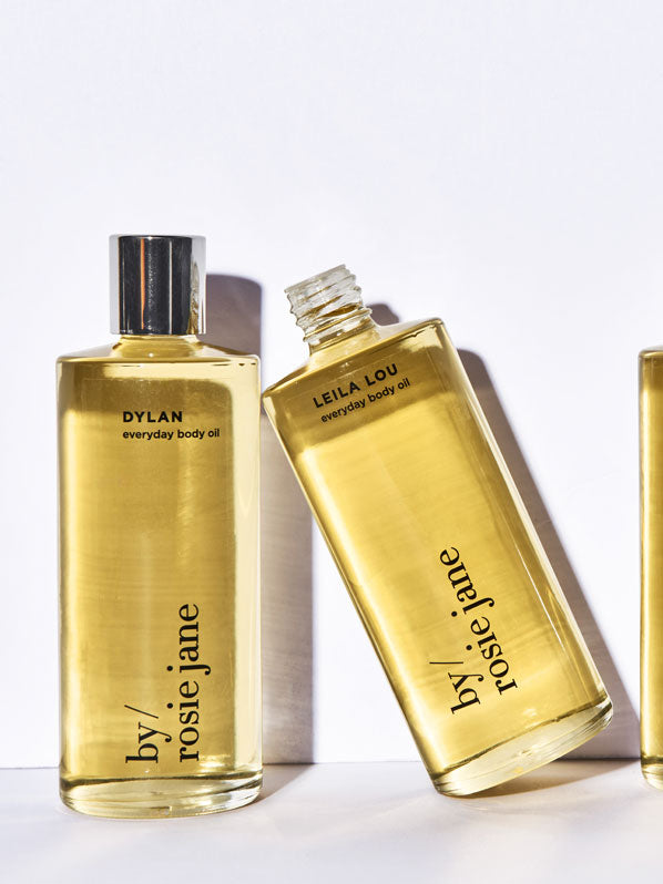 A close-up of several cosmetic bottles, including one with a black label, arranged together. They appear to be toiletry or perfume products.