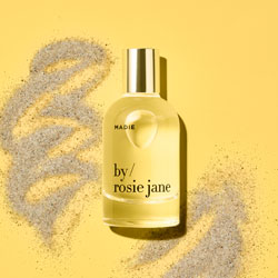 A bottle of perfume set against a yellow background.