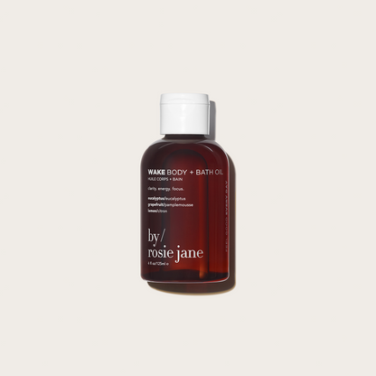 Bottle of 'Wake Body + Bath Oil' by rosie jane on a tan background