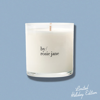 Candle with 'by rosie jane' text on a light blue background