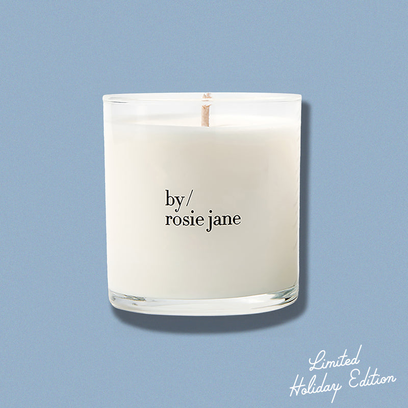 Candle with 'by rosie jane' text on a light blue background