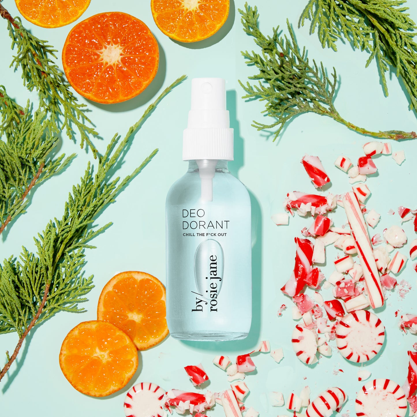 Chill the F*ck Out Deodorant Refill spray bottle beside oranges and candy, highlighting its aluminum-free, odor-blocking formula, and refill capacity.