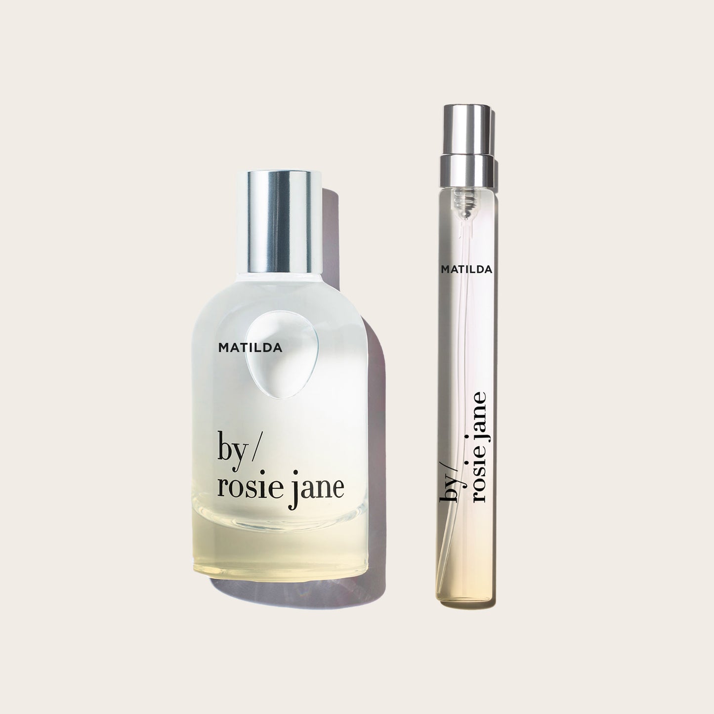 Matilda by Rosie Jane perfume bottle next to a matching travel atomizer spray vial, both with silver caps, on a light beige background.