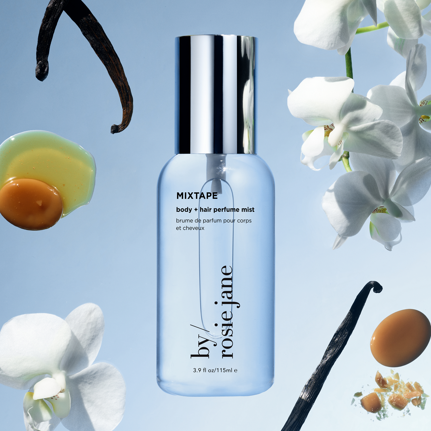 A bottle of ROSIE JANE MIXTAPE body + hair perfume mist centered on a light blue background, surrounded by floating vanilla beans, white orchid flowers, and vanilla seeds. The bottle is clear with a silver cap and black text.