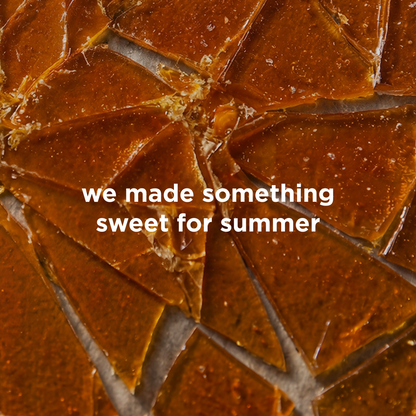 A close-up of glossy amber-brown translucent triangular pieces arranged in a mosaic pattern, with white text across the center reading 'we made something sweet for summer'.