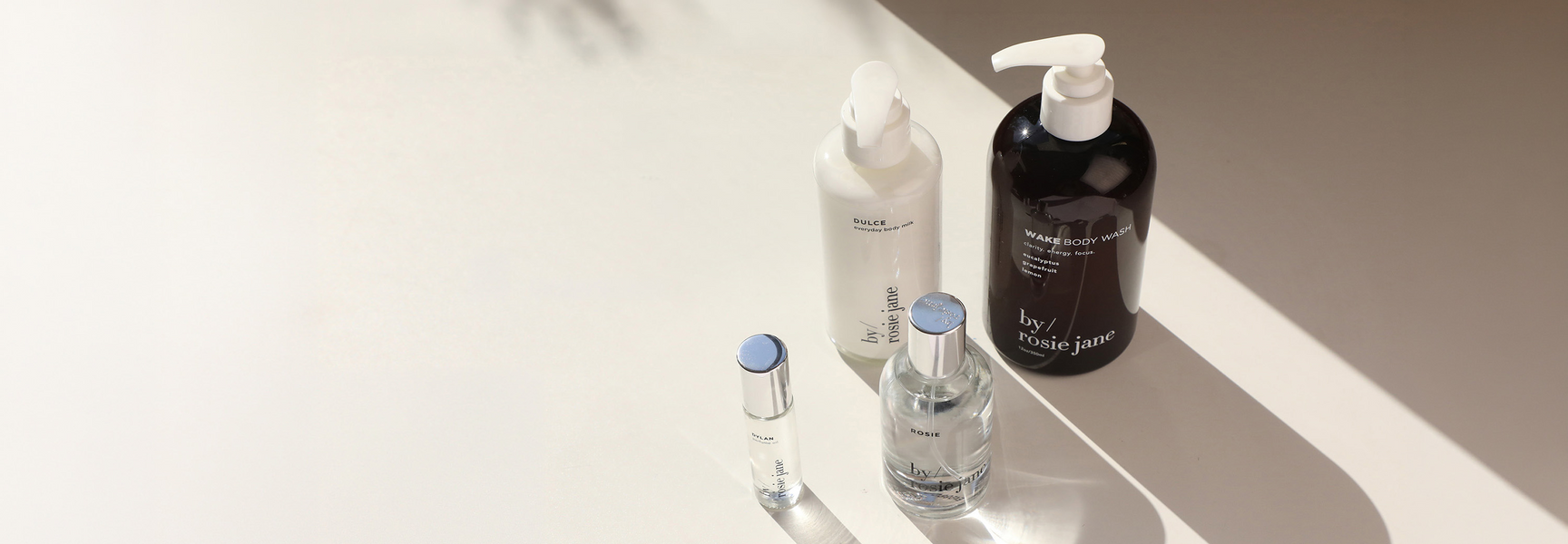 Set of skincare products on a reflective surface with a neutral background