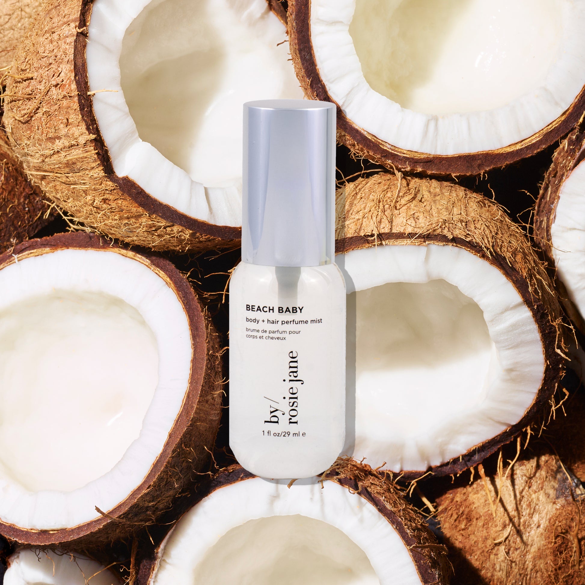 Rosie Jane mini Beach Baby perfume bottle surrounded by coconut halves