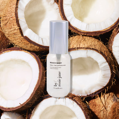 Rosie Jane mini Beach Baby perfume bottle surrounded by coconut halves