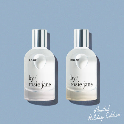 Rosie and Dulce 'by Rosie Jane' perfume bottles on a light blue background 