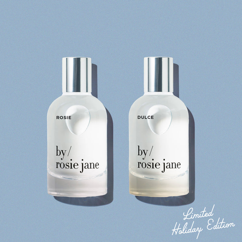 Rosie and Dulce 'by Rosie Jane' perfume bottles on a light blue background 