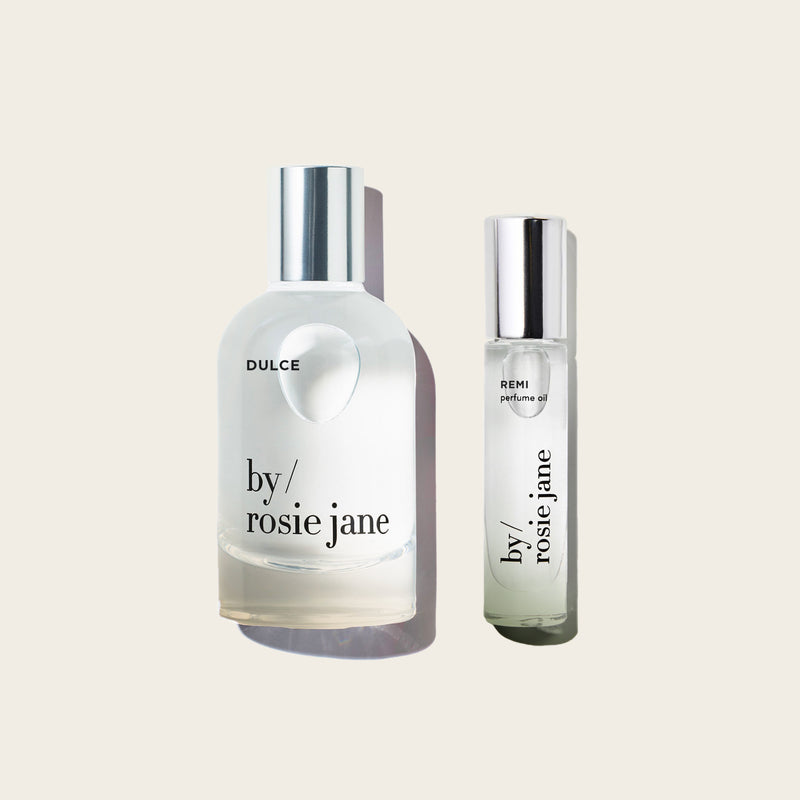 Two perfume bottles labeled 'by rosie jane' on a light beige background
