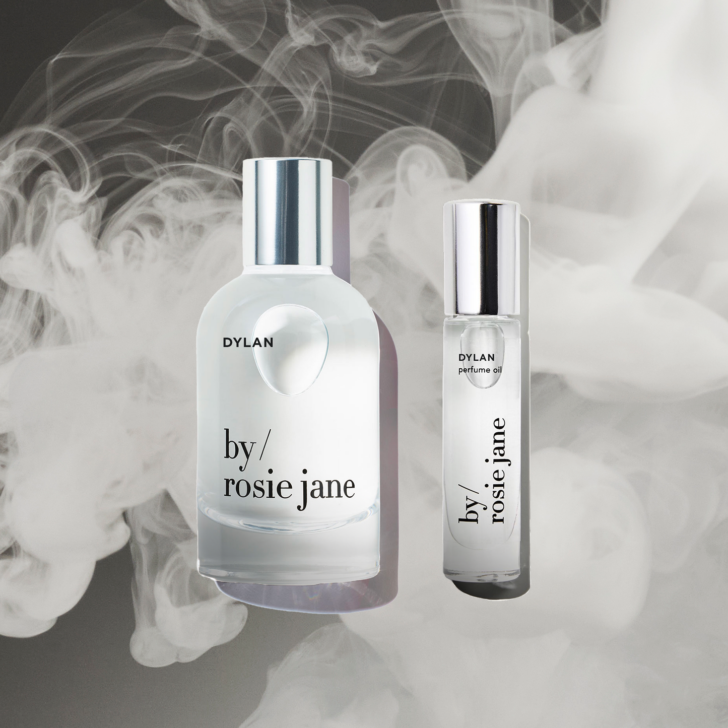 The byrosiejane DYLAN LAST ALL DAY SET, featuring a full-size Eau de Parfum spray and a travel-size Perfume Oil, is shown against a smoky backdrop to emphasize their long-lasting fragrance.