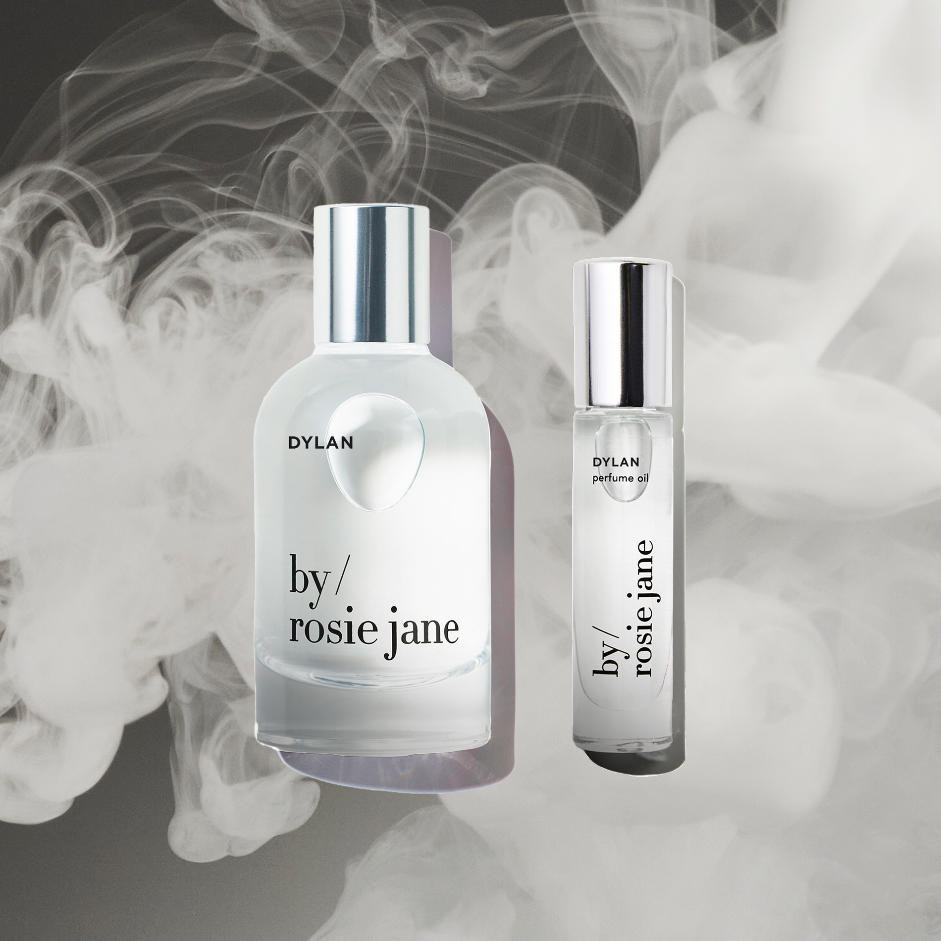 The byrosiejane DYLAN LAST ALL DAY SET, featuring a full-size Eau de Parfum spray and a travel-size Perfume Oil, is shown against a smoky backdrop to emphasize their long-lasting fragrance.