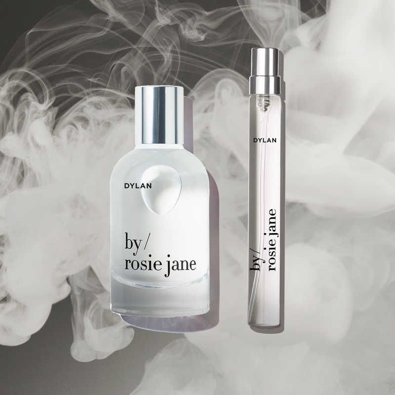 The DYLAN HOME + AWAY SET by byrosiejane features a glass perfume bottle and travel spray displayed against a smoky background, making it the perfect limited edition Mothers Day gift.