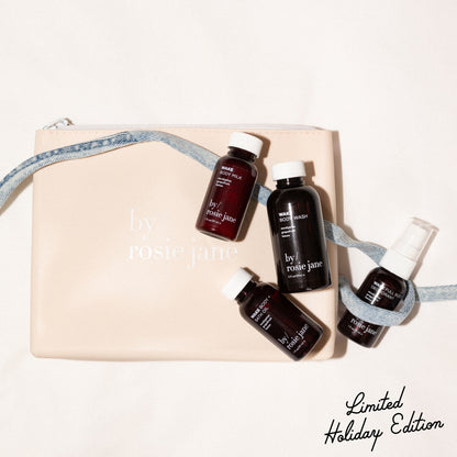 Set of mini travel size skincare products with 'by rosie jane' branding on a beige silicone bag