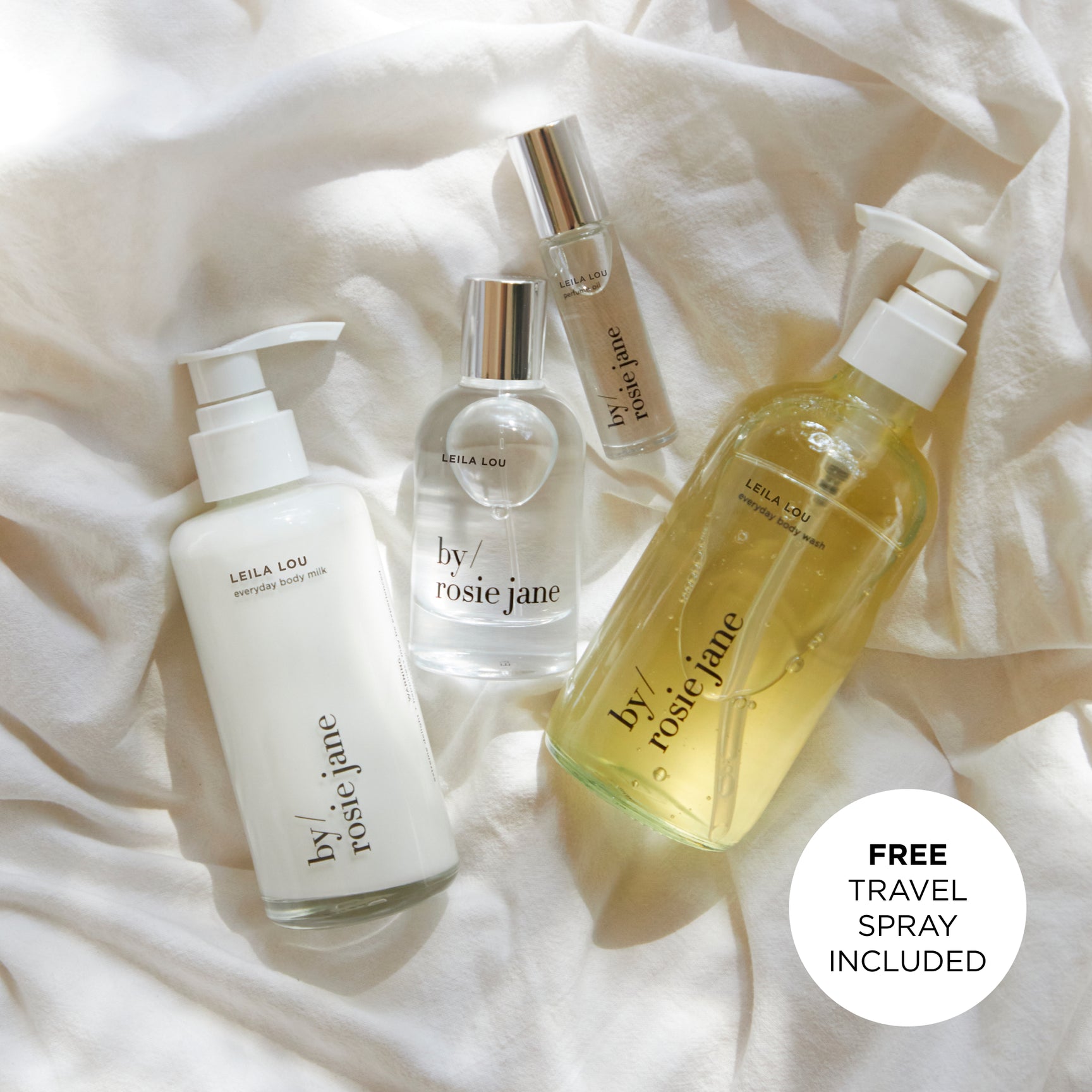 Four leila lou skincare products from 'by rosie jane' on a soft white fabric background.