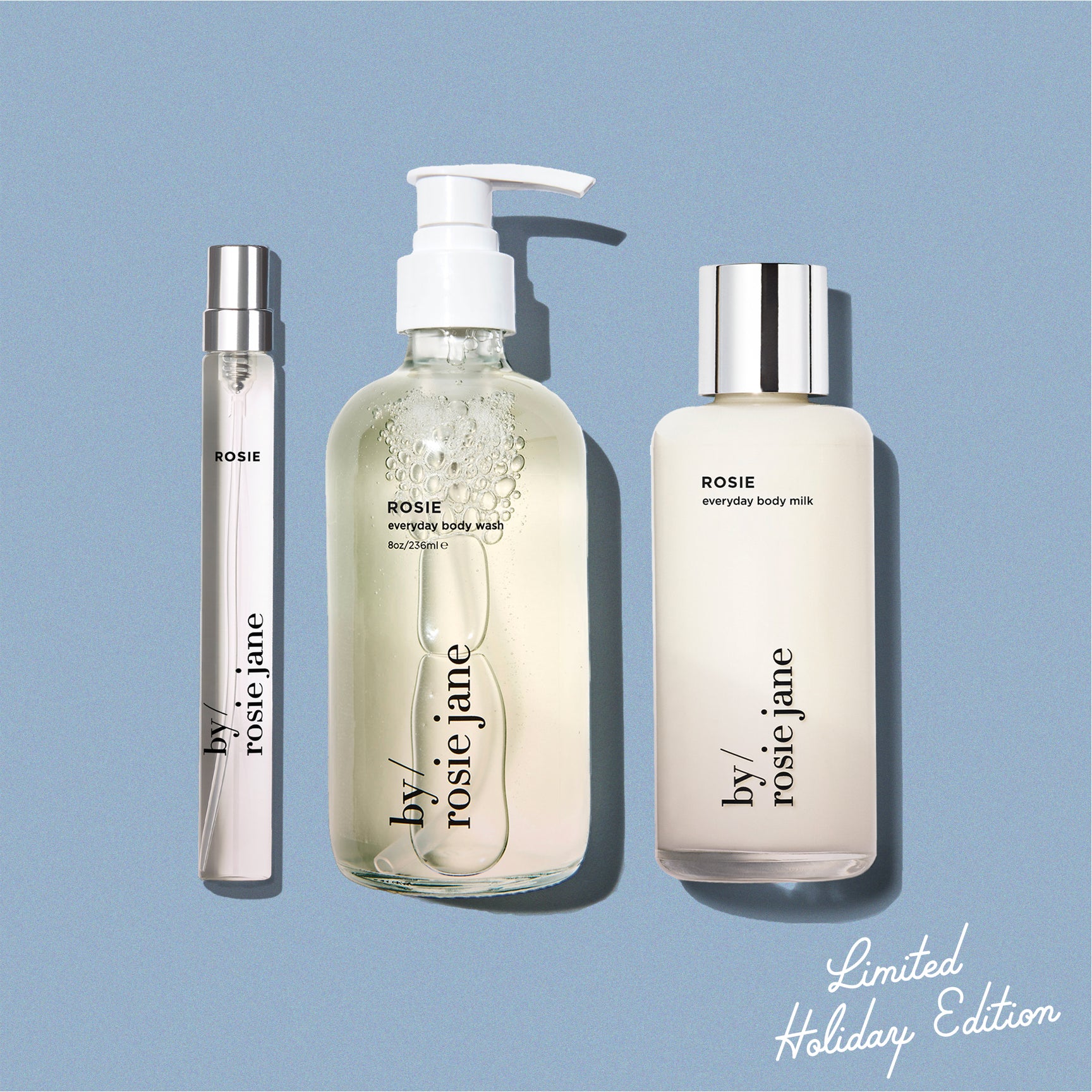 blue background displaying ROSIE travel spray, ROSIE body wash, and ROSIE body milk