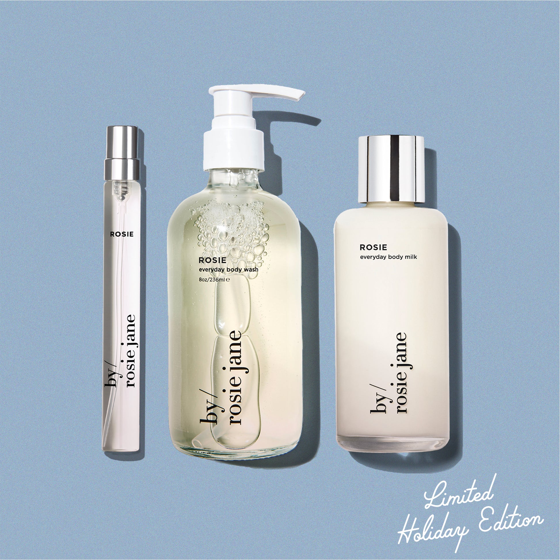 blue background displaying ROSIE travel spray, ROSIE body wash, and ROSIE body milk