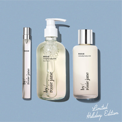 blue background displaying ROSIE travel spray, ROSIE body wash, and ROSIE body milk