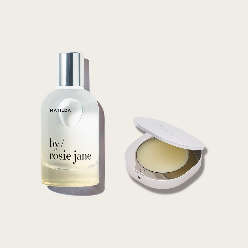 MATILDA Bottle of 'by Rosie Jane' perfume next to a SOLID PERFUME with a cream product on a light beige background