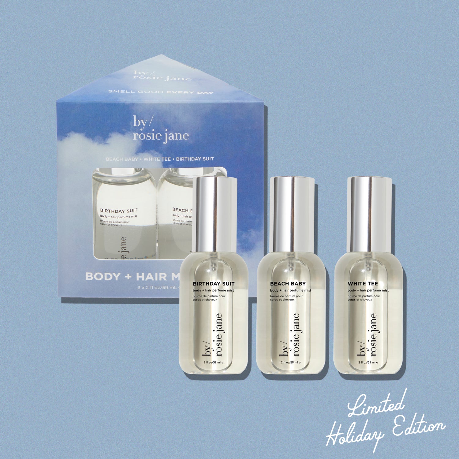 Set of three body + hair mist bottles with a limited edition holiday box on a light blue background, featuring 'bv/ rosie jane' brand. set includes birthday suit, beach baby, and white tee.