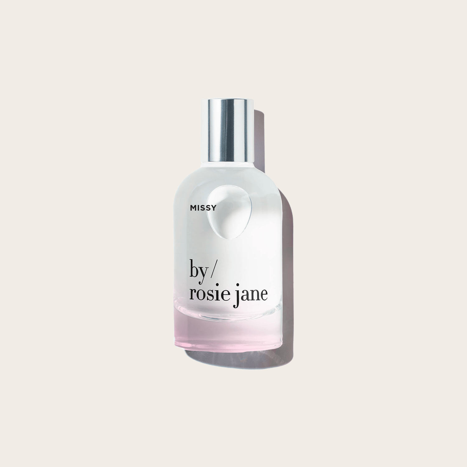 A clear glass bottle labeled MISSY PERFUME by byrosiejane with a silver cap and pale pink liquid featuring coconut notes, displayed on a light beige background with a gentle shadow.