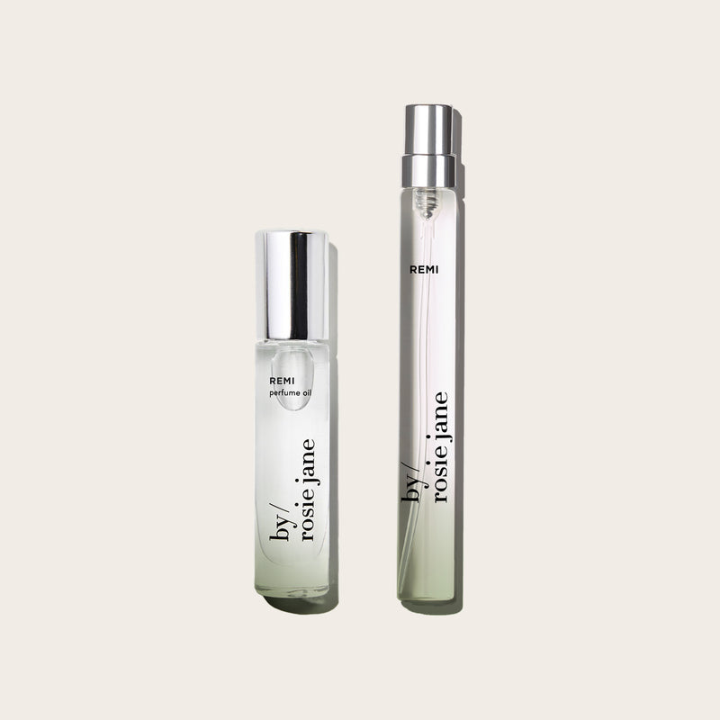 Two perfume bottles labeled 'REMI' and 'by rosie jane' on a light beige background
