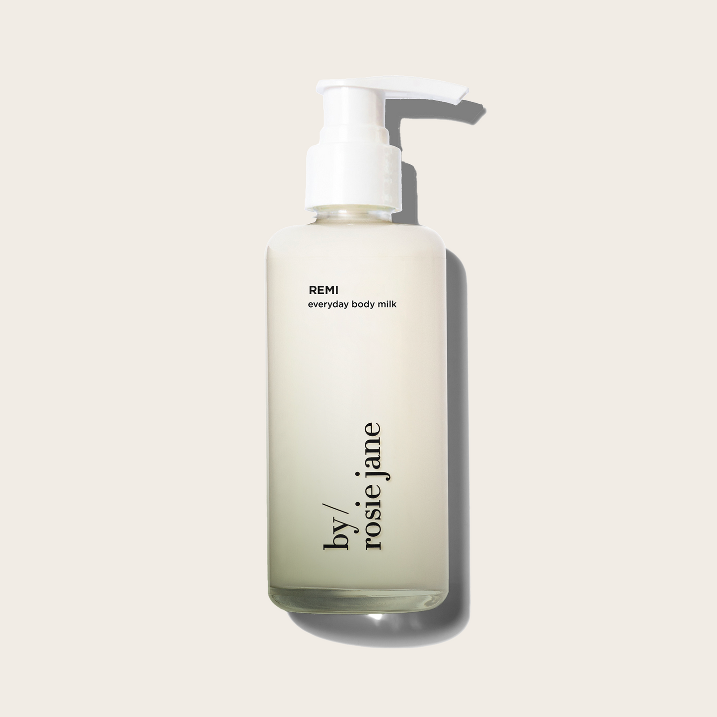 Bottle of REMI everyday body milk by rosie jane on a light beige background