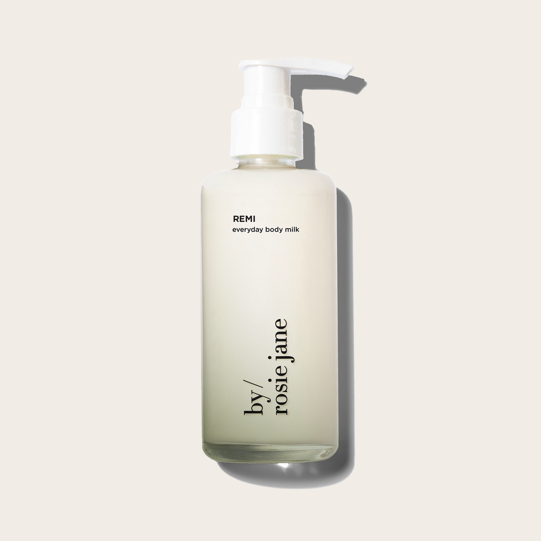Bottle of REMI everyday body milk by rosie jane on a light beige background