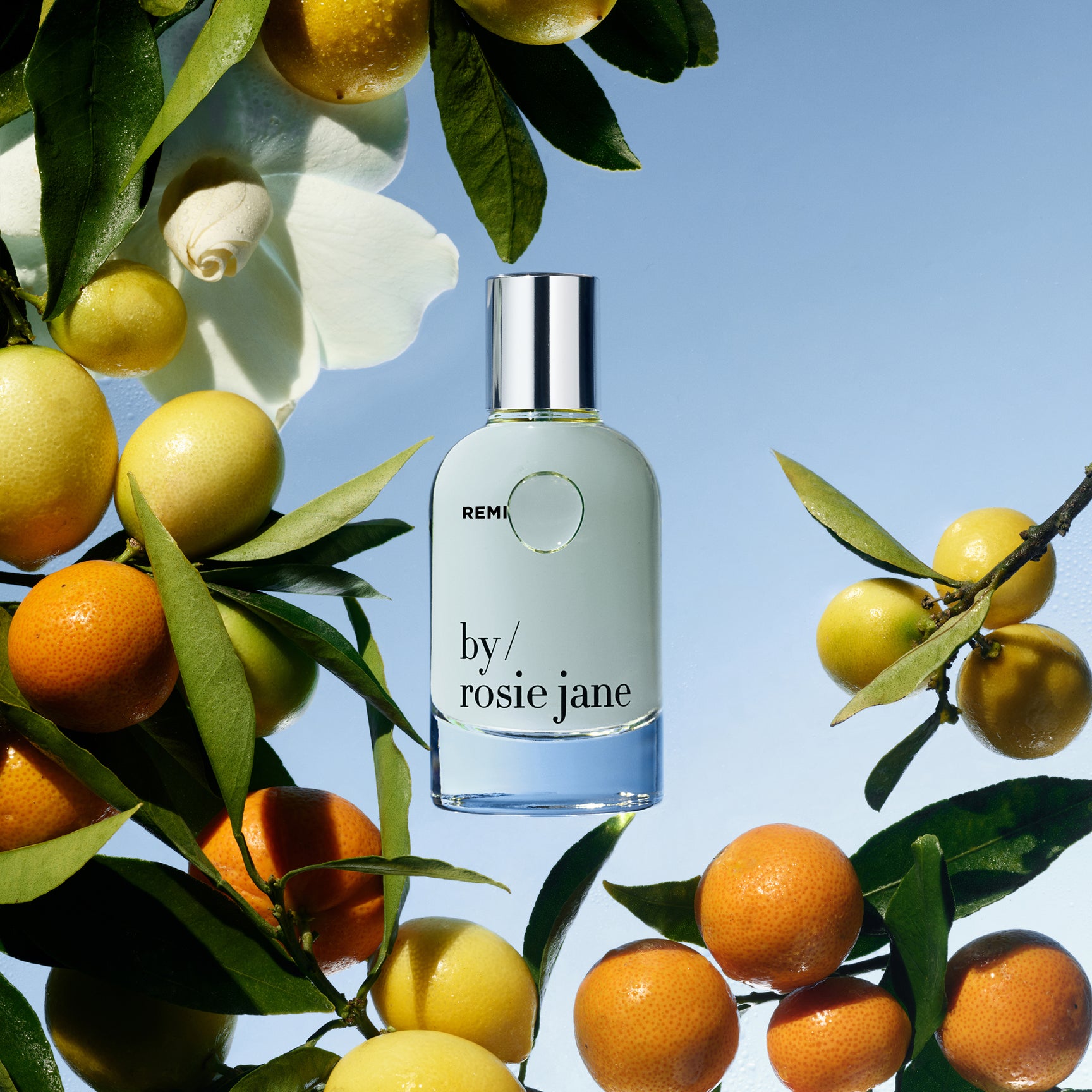 REMI bottle on mandarin and gardenia background