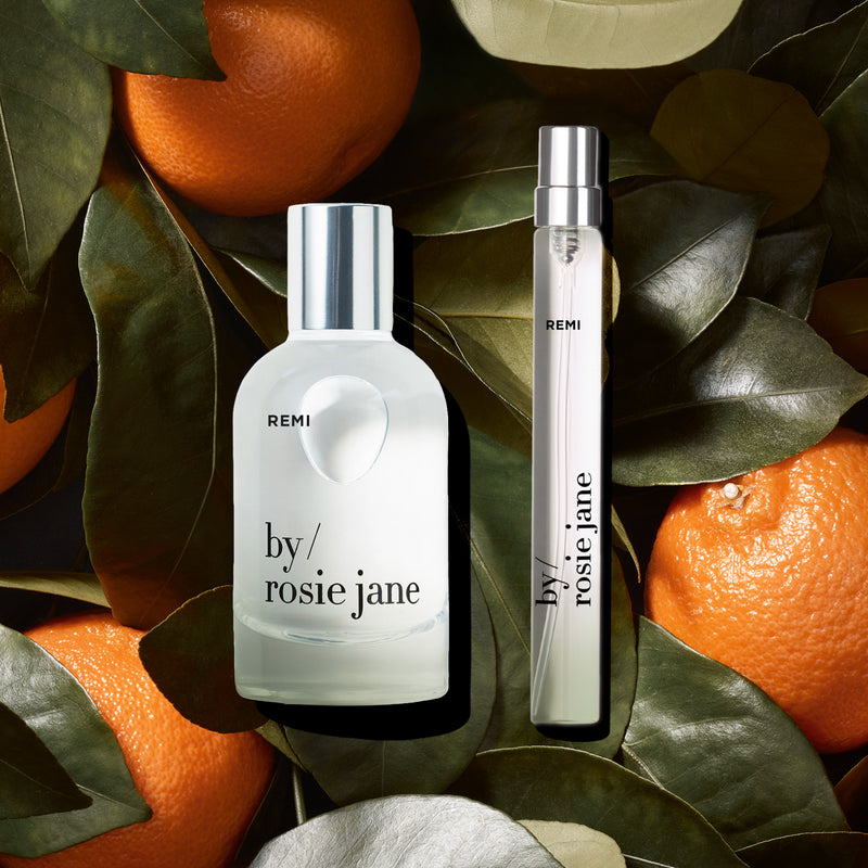 remi edp and travel spray on a background of mandarins