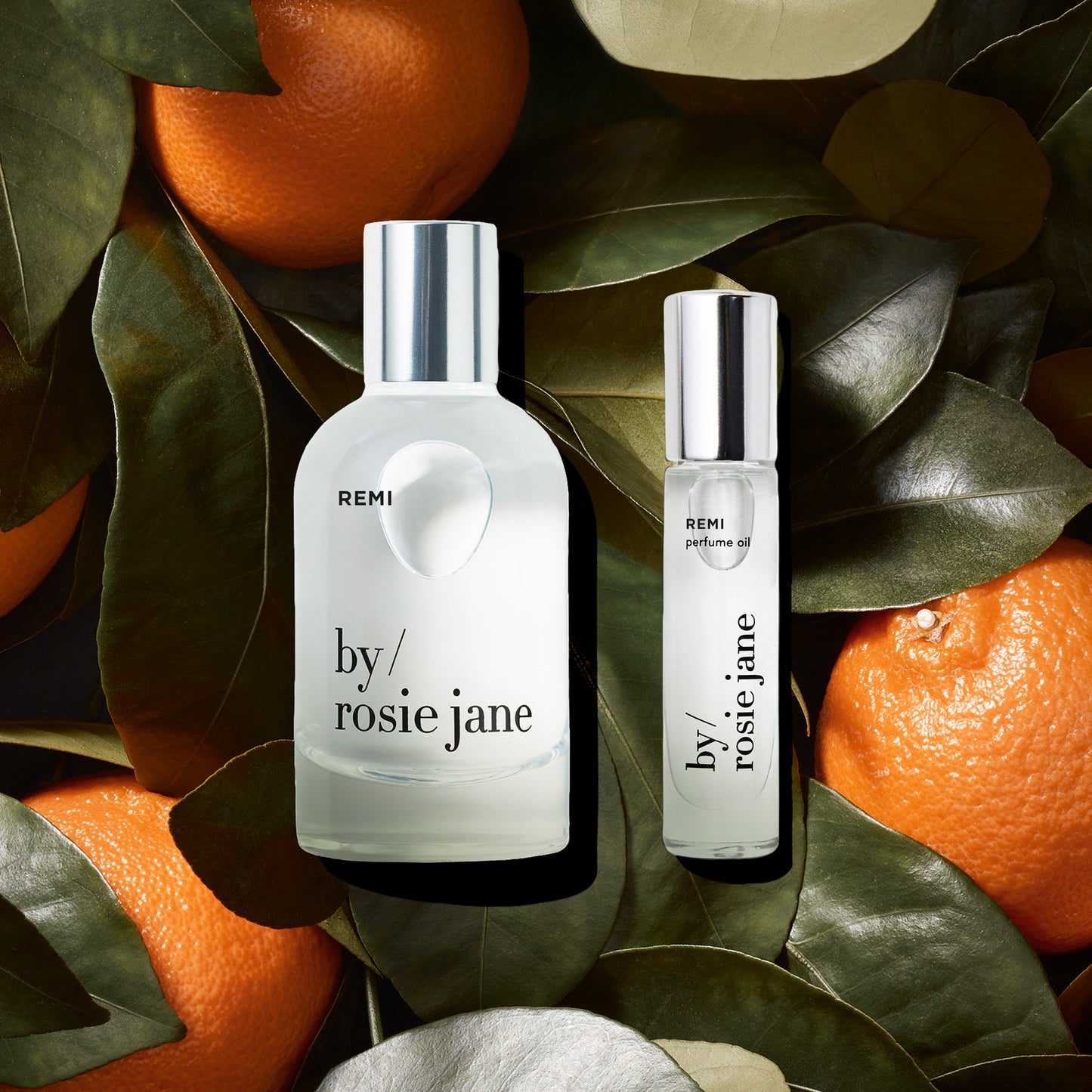 Two bottles of remi 'by Rosie Jane' on a leafy background with oranges.