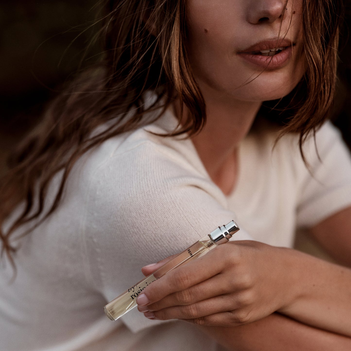 woman holding REMI travel spray