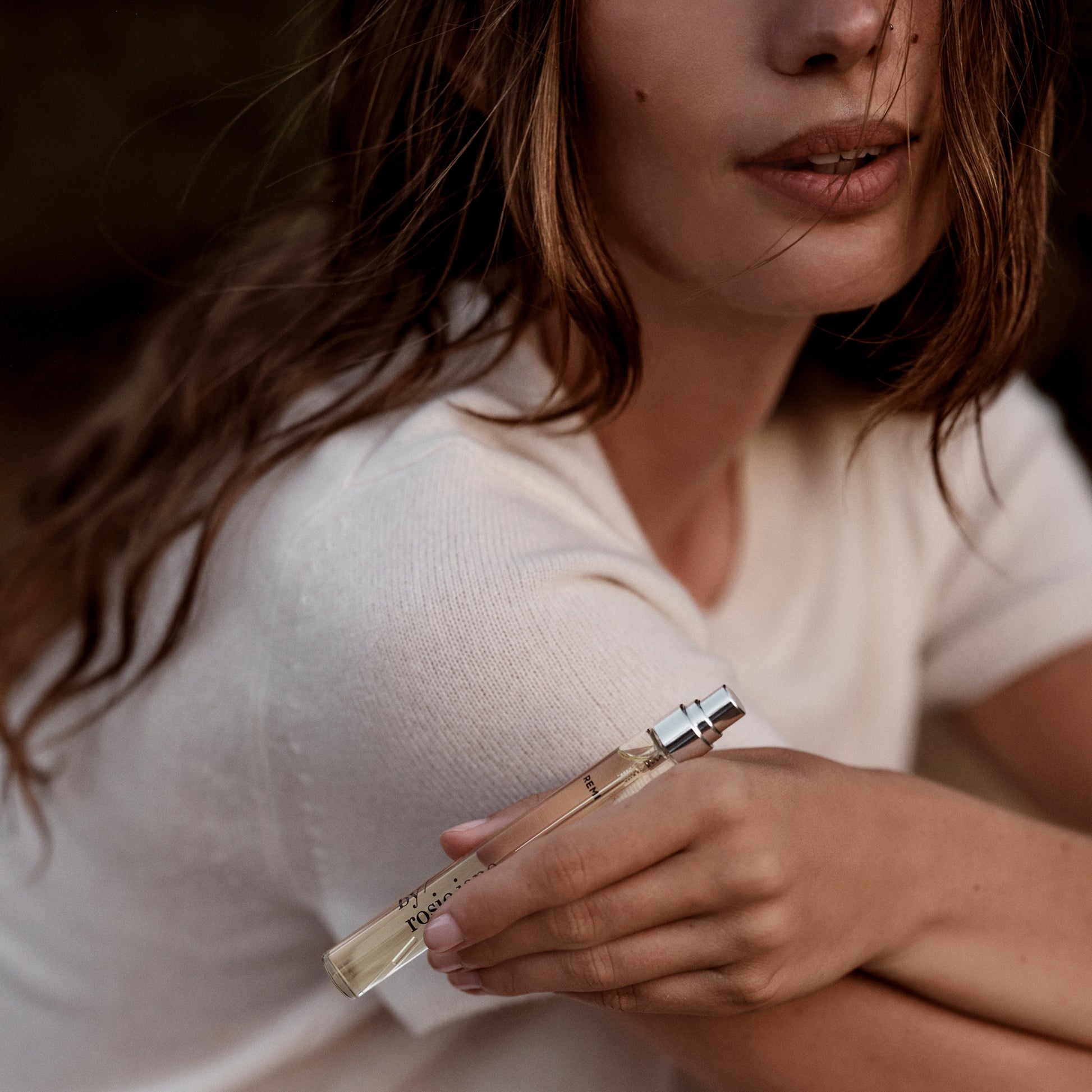 woman holding REMI travel spray