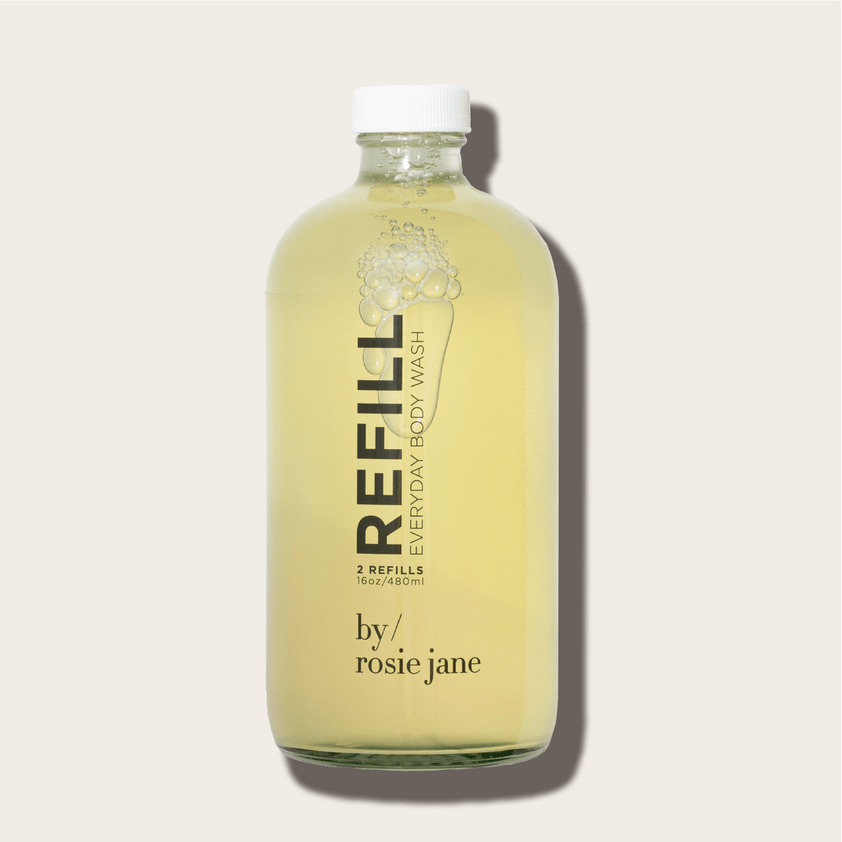 A clear glass bottle filled with yellow liquid, labeled ROSIE BODY WASH REFILL byrosiejane, sits on a light beige background. Its minimalist design features a metal cap and a formula made with organic white tea extract.