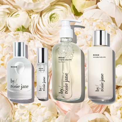 Rosie perfume, perfume oil, body wash, and body milk on roses 