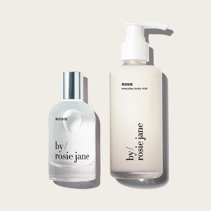 Two bottles of ROSIE 'by Rosie Jane' products on a light beige background