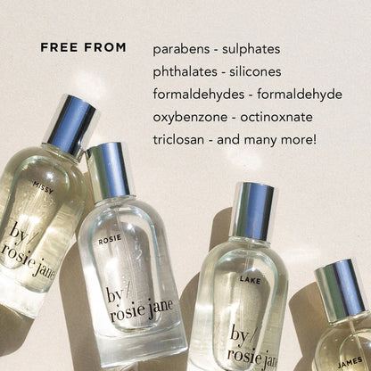 Four perfume bottles with metallic caps on a beige background, featuring text about product ingredients.