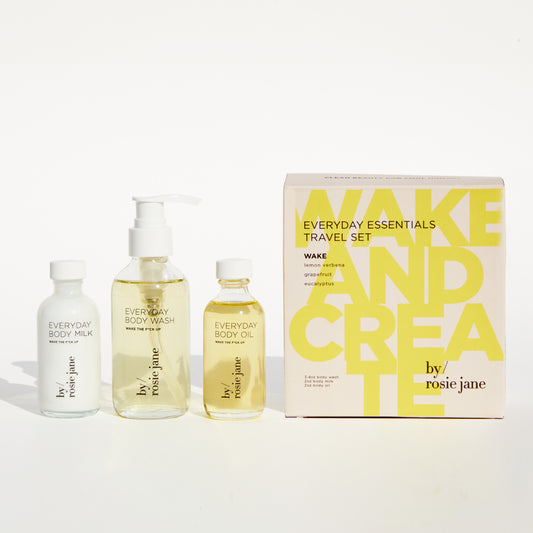 Wake + Create Set features bottles of body wash, body milk, and body oil next to a box, promoting skin hydration and mood enhancement.