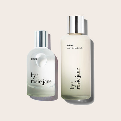 Two bottles of REMI 'by Rosie Jane' products on a light beige background