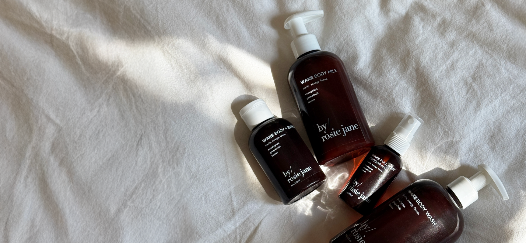 Set of WAKE skincare bottles on a textured white surface